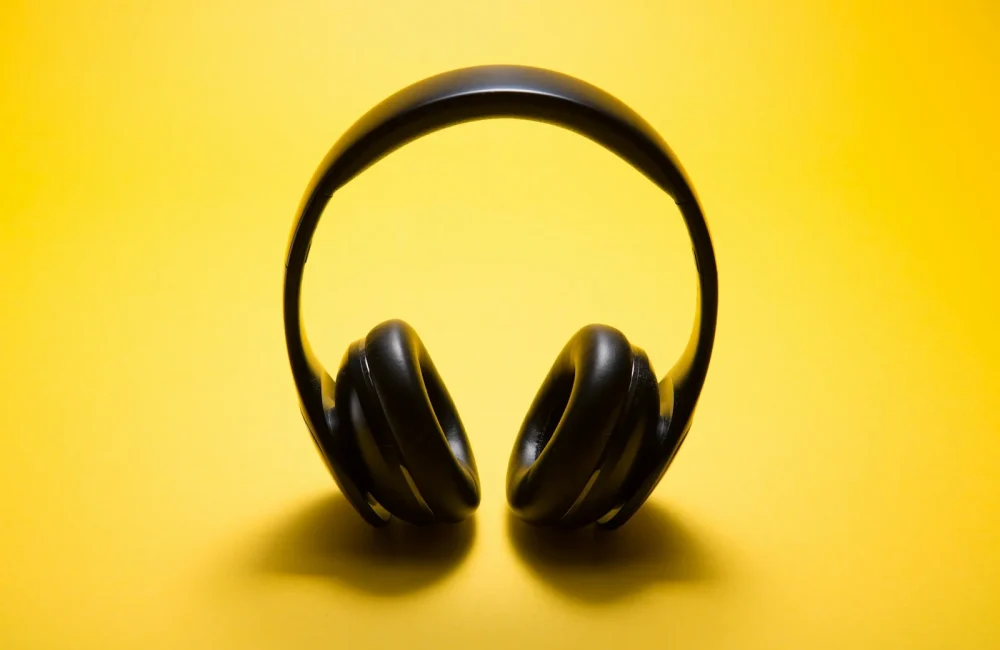 Auriculares inalámbricos negros sobre fondo amarillo