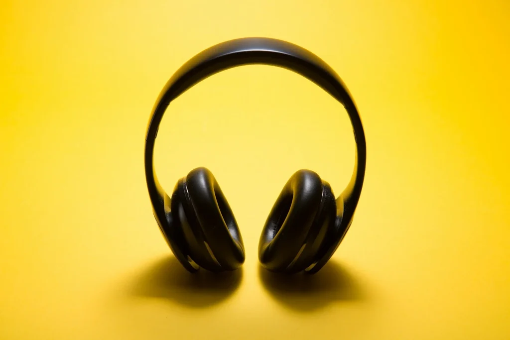 Auriculares inalámbricos negros sobre fondo amarillo