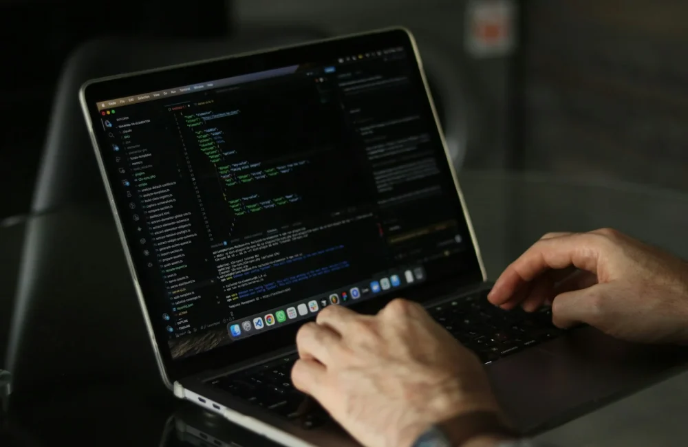 Manos escribiendo en el teclado de un portátil