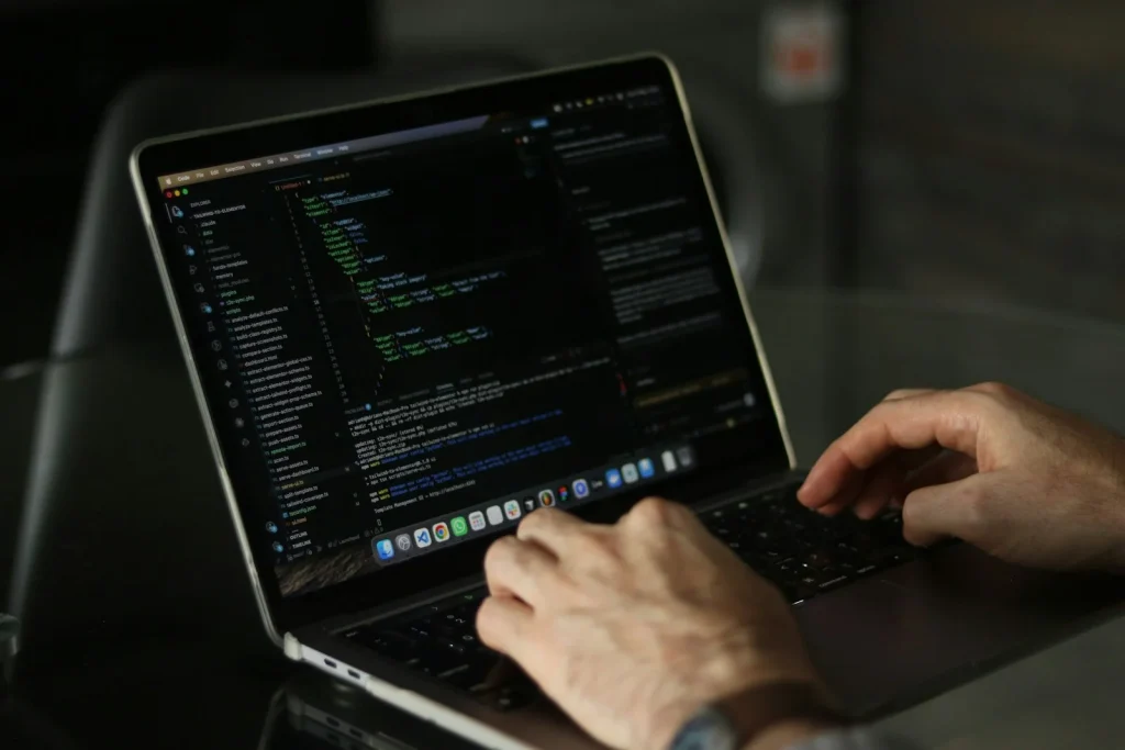 Manos escribiendo en el teclado de un portátil