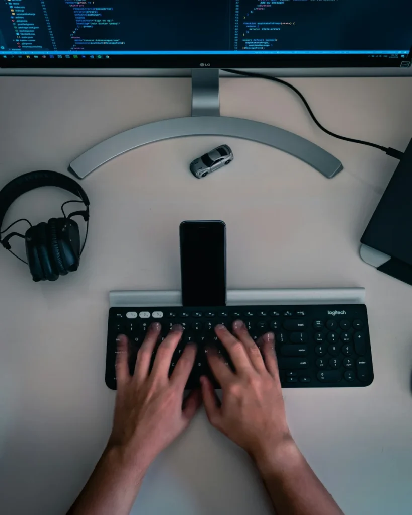 Pantalla, teclado, teléfono y auriculares en un escritorio