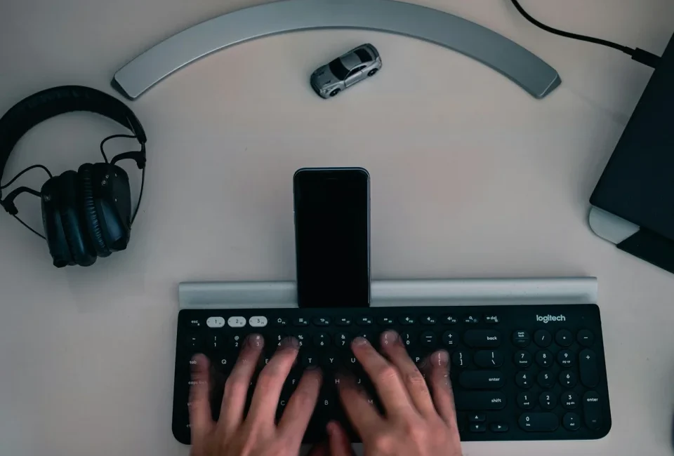 Pantalla, teclado, teléfono y auriculares en un escritorio